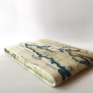 May include: A cream-colored, rectangular case featuring a vintage world map design. The map includes blue oceans, brown landmasses, and text labels. The case is folded and appears to be made of fabric.