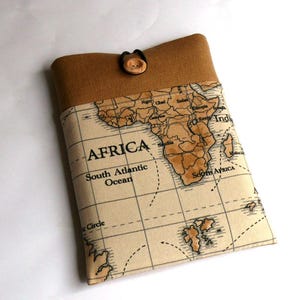 May include: A brown fabric case with a map of Africa printed on it. The case has a brown flap with a button closure. The map shows the continent of Africa with the text "AFRICA" and "South Atlantic Ocean".