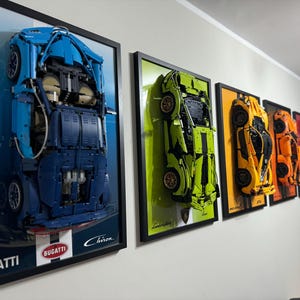 Peut inclure: Une exposition murale d'œuvres d'art encadrées représentant différents modèles de voitures. Le premier cadre montre une Bugatti Chiron bleue, le deuxième cadre montre une Lamborghini verte, le troisième cadre montre une McLaren jaune, le quatrième cadre montre une Ferrari orange et le cinquième cadre montre une voiture rouge.