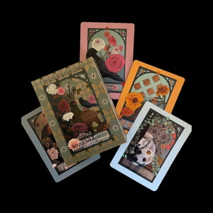 May include: A set of tarot cards with botanical and animal artwork. The cards display a deer, sheep, peacock, crow, and flowers. The cards have a vintage style. The text "SOULS journey SEED" is visible on one card.