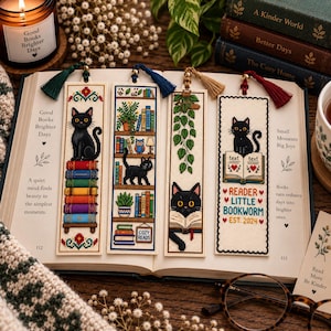 Peut inclure: Quatre marque-pages rectangulaires en point de croix représentant des chats noirs et des motifs sur le thème des livres. Chaque marque-page possède un pompon coloré. Les motifs incluent un chat sur des livres, une étagère, un chat qui lit et le texte READER LITTLE BOOKWORM EST. 2024.