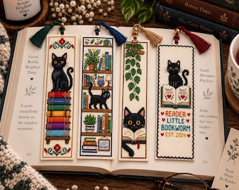 May include: Four rectangular cross-stitch bookmarks featuring black cats and book-themed designs. Each bookmark has a colored tassel at the top. The designs include a cat on a stack of books, a cat on a bookshelf, a cat reading, and a cat with the text READER LITTLE BOOKWORM EST. 2024.