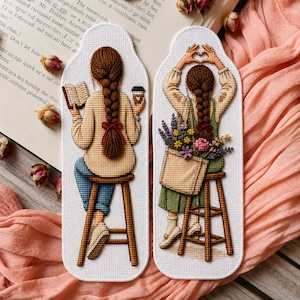 Peut inclure: Deux marque-pages verticaux en broderie au point de croix. Le marque-page de gauche montre une personne avec une tresse brune assise sur un tabouret, lisant un livre et tenant un café. Celui de droite montre une personne avec une tresse brune formant un cœur avec ses mains, portant une robe verte et un sac fourre-tout rempli de fleurs colorées.