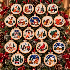 May include: A collection of nineteen circular wooden embroidery hoops featuring cross-stitch designs of woodland animals, winter scenes, and holiday motifs, each suspended by a red ribbon against a green pine tree background.