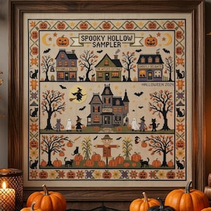 May include: A framed cross-stitch sampler titled Spooky Hollow Sampler Halloween 2024, featuring embroidered houses, a haunted mansion, a scarecrow, pumpkins, black cats, ghosts, and witches on a beige fabric background within a wooden frame.
