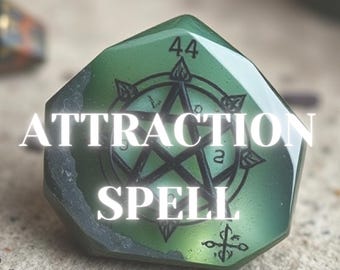 May include: A green, faceted stone with the words "ATTRACTION SPELL" in white. A black pentagram design is centered on the stone, with the number "44" and other symbols. The stone has a slightly translucent quality.