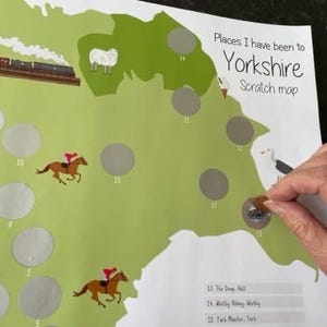 May include: A Yorkshire scratch map with a green and white design, featuring illustrations of a train, sheep, and racehorses. The map includes silver scratch-off circles and the text "Places I have been to Yorkshire Scratch map".