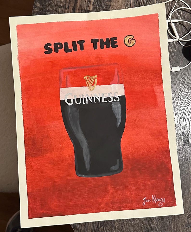 以下が含まれることがあります： 赤い背景に黒い文字で「SPLIT THE G」と書かれています。テキストの隣には金色の文字「G」があります。画像の中央には、ギネスビールのジョッキの白黒のイラストがあります。ジョッキには「GUINNESS」の文字が印刷されています。画像は右下に「Jace Neary」の署名があります。