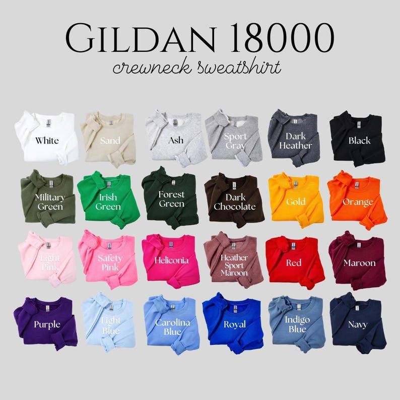 May include: A Gildan 18000 crewneck sweatshirt colour chart displaying twenty-four folded garments in various shades including white, sand, ash, grey, black, green, brown, gold, orange, pink, red, maroon, purple, blue, and navy with labels.