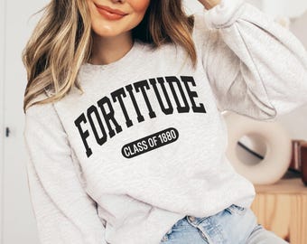 Könnte beinhalten: Ein aschgraues Sweatshirt mit Rundhalsausschnitt und dem schwarzen Schriftzug FORTITUDE in einer geschwungenen College-Schriftart, wobei der Text CLASS OF 1880 in einem schwarzen, abgerundeten Rechteck unter dem Hauptwort steht.