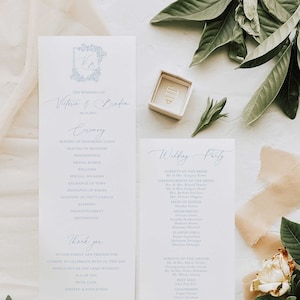 May include: A wedding ceremony and reception program with a blue and white color scheme. The program lists the order of events for the ceremony and the names of the wedding party members. The text "The Wedding of Victoria & Braden" is at the top of the ceremony program.