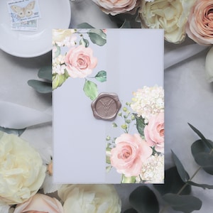 May include: A light blue invitation card with a watercolor floral design featuring pink roses, white hydrangeas, and green leaves. A wax seal with a decorative design is on the card.