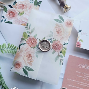 May include: A white envelope with a floral design and a wax seal. The envelope is decorated with watercolor pink and peach roses and green leaves. The wax seal is gold and has a floral design.