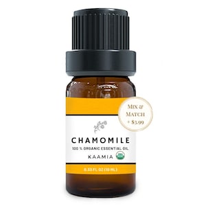May include: A brown glass bottle of chamomile essential oil with a black cap. The label features the word "CHAMOMILE" and "100% ORGANIC ESSENTIAL OIL". The bottle contains 0.33 fl oz (10 mL) of oil.