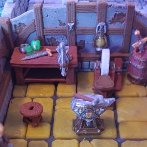 Puede incluir: Un taller de herrero en miniatura con un banco de trabajo, un yunque, una muela y un barril. El banco de trabajo está equipado con varias herramientas y suministros, incluyendo una espada, un martillo y una botella de líquido verde. El yunque está hecho de metal y tiene un mango de madera. La muela está hecha de piedra y tiene un marco de madera. El barril está hecho de madera y tiene una banda de metal alrededor.