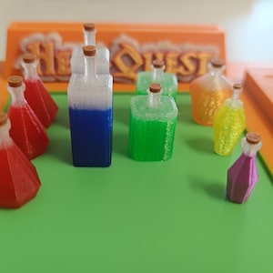 May include: A collection of colorful potion bottles with cork stoppers, arranged on a green surface. The bottles are filled with various liquids in shades of red, blue, green, yellow, and purple. An orange game board with the text "Hero Quest" is in the background.