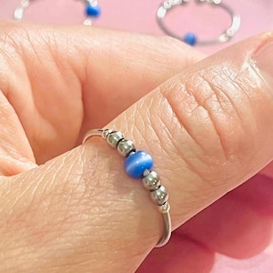 Blauwe antistressring met kattenoogmotief – Verstelbare ring, roestvrij staal en draaiende kralen voor concentratie en verlichting van angst.