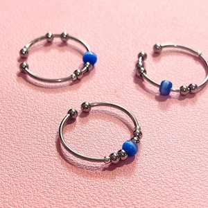 Blauwe antistressring met kattenoogmotief – Verstelbare ring, roestvrij staal en draaiende kralen voor concentratie en verlichting van angst.