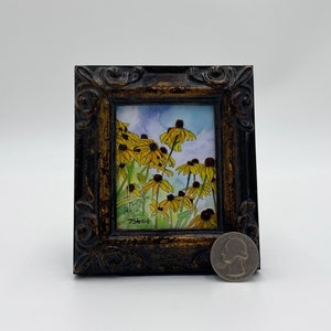 May include: A framed watercolor painting of a field of yellow wildflowers with a blue sky in the background. The painting is signed "J.Sheck" in the lower left corner.