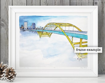 May include: A watercolor painting of a yellow bridge over a river with a city skyline in the background. The bridge is painted in a bright yellow with a teal road. The city skyline is in the distance and is painted in shades of blue and gray. The painting is framed in a white frame.