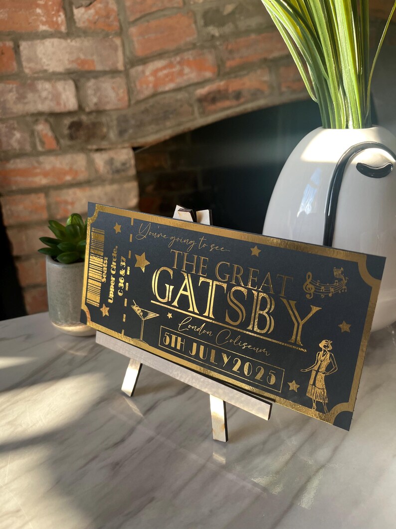 May include: A black and gold ticket with the text "You're going to see... The Great Gatsby" and "London Coliseum 5th July 2025".