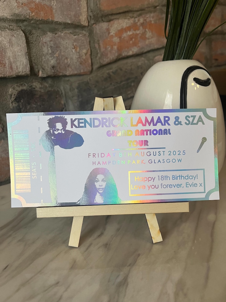 May include: A holographic ticket for a Kendrick Lamar and SZA concert. The ticket says "Grand National Tour" and lists the date as "Friday 3rd August 2025" and the location as "Hampden Park Glasgow". The ticket also has a birthday message that says "Happy 18th Birthday! Love you forever, Evie x".