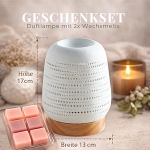 Könnte beinhalten: Ein weißer Keramik-Duftdiffusor mit Holzsockel, 17 cm hoch und 13 cm breit. Der Diffusor hat ein perforiertes Design und wird mit Wachsmelts in Rosatönen geliefert. Der Text "GESCHENKSET" ist sichtbar.