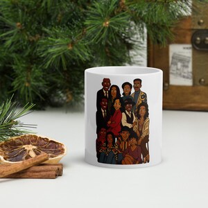 Peut inclure: Une tasse en céramique blanche avec une illustration de dessin animé colorée d'un groupe de personnes. L'illustration présente un groupe diversifié de personnes avec différentes coiffures, vêtements et expressions. La tasse est un excellent cadeau pour les fans de la série.