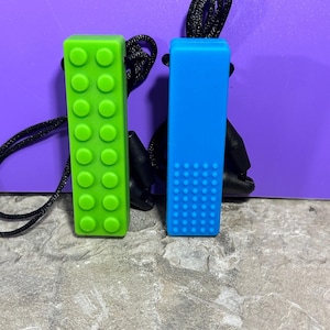 adult chewelry chew necklace - looks like a building brick block on the front and soothing bumps on the back. has a safety break away necklace. colors are: blue or green