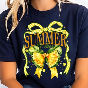 May include: A navy blue t-shirt with a yellow and green bow and the text "SUMMER Vibes".