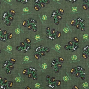 May include: A dark green fabric featuring a repeating pattern of small green tractors and yellow deer logos. The tractors are depicted in various orientations across the textile, interspersed with the iconic yellow deer emblem on a green square background.