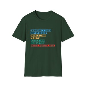 May include: A dark green t-shirt with a white, blue, yellow, orange, and red graphic print that reads "Democracy Over Dictatorship, People Over Profits, Justice, Not Corruption, Resist. Persist. Rise."