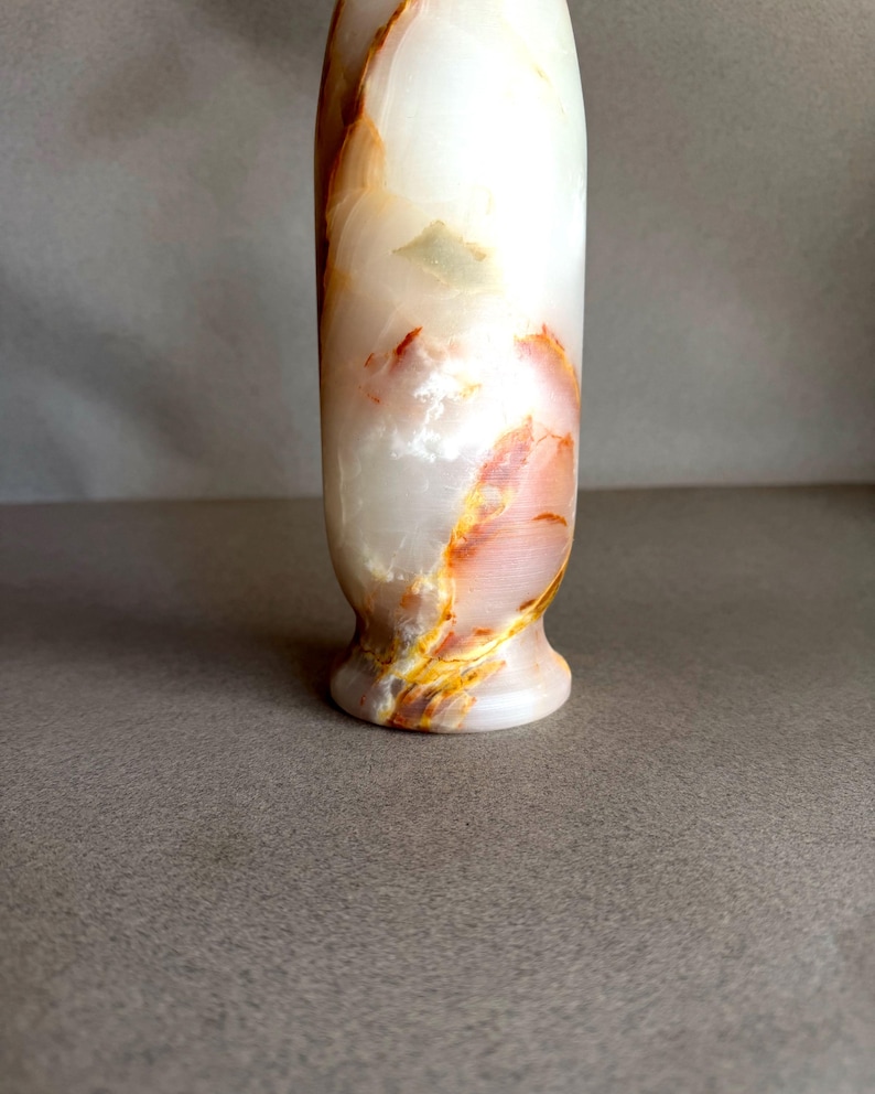 Pode incluir: Um vaso decorativo alto feito de &ocirc;nix branco com listras laranja e amarelo. O vaso tem uma base alargada e uma superf&iacute;cie lisa e polida. A pedra natural tem uma qualidade transl&uacute;cida.