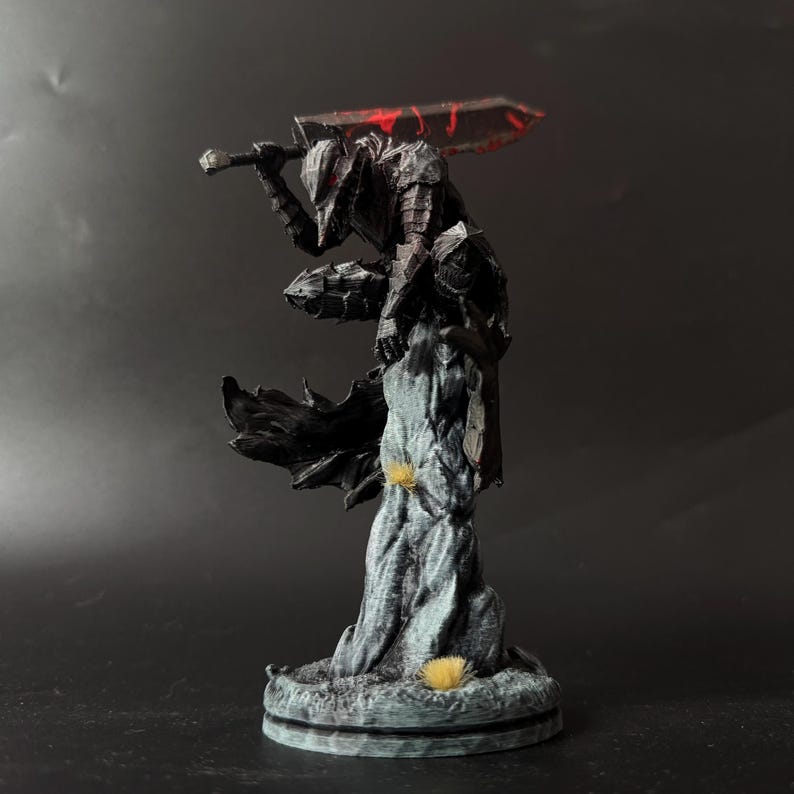 Puede incluir: Una figura detallada de un guerrero con armadura oscura en pose agachada, posado sobre un pilar de piedra texturizado. El personaje viste una armadura de placas negra con ojos rojos brillantes y sostiene una espada grande y pesada con detalles rojos.