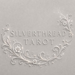 Könnte beinhalten: Der Text SILVERTHREAD TAROT ist auf einem hellgrauen Hintergrund zentriert und von einem komplizierten, geprägten weißen Blumenrankenmuster mit wirbelnden Ornamenten, kleinen Perlen und subtilen funkelnden Lichteffekten umrahmt.