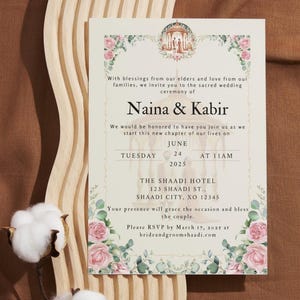 Könnte beinhalten: Eine Hochzeitseinladung mit floralen Akzenten in Rosa- und Grüntönen. Die Einladung zeigt die Namen "Naina & Kabir" und Details zu einer Hochzeitszeremonie am 24. Juni 2025 um 11:00 Uhr im The Shaadi Hotel. Die Einladung enthält auch die Adresse und eine Bitte um RSVP bis zum 17. März 2025.