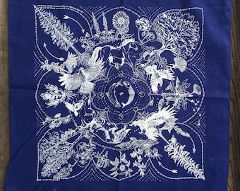 May include: A square, navy blue bandana with a white, intricate design. The design features a horse, birds, fish, and various botanical elements. The bandana is made of a soft fabric and is likely machine washable.