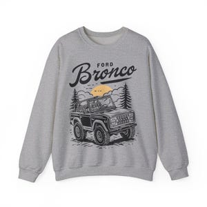 The Ford Bronco Adventure Sweatshirt exudes a sense of adventure and ruggedness, perfect for outdoor enthusiasts and fans of the iconic vehicle. This cozy sweatshirt is made with a medium-heavy fabric blend of 50% cotton and 50% polyester, providing