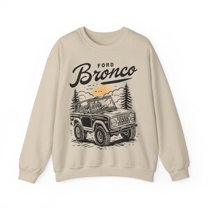 The Ford Bronco Adventure Sweatshirt exudes a sense of adventure and ruggedness, perfect for outdoor enthusiasts and fans of the iconic vehicle. This cozy sweatshirt is made with a medium-heavy fabric blend of 50% cotton and 50% polyester, providing