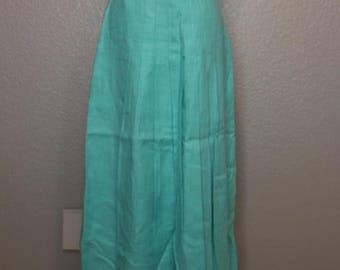 May include: A long, pleated skirt in a light turquoise color. The skirt is made of a lightweight fabric and has a simple, classic design.