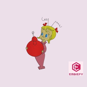 May include: An embroidered design of a cartoon character holding a large red ornament. The character has blonde hair, blue eyes, and is wearing a pink outfit. The design is on a light pink background.