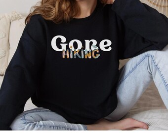 May include: A black sweatshirt with the text "Gone Hiking" in white letters with a floral design.