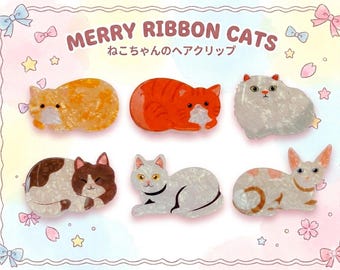 May include: Six cat-shaped hair clips in various colors and patterns. The clips include orange, red, white, brown, and calico designs. The text "MERRY RIBBON CATS" and Japanese text are at the top.
