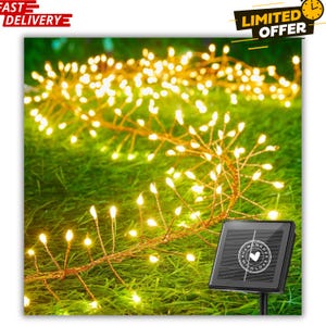 May include: Solar-powered string lights with warm white LED bulbs, arranged in a starburst pattern, are displayed on green grass. The lights are connected to a small solar panel with the text "HAND MADE WITH LOVE". The image also includes the text "FAST DELIVERY" and "LIMITED OFFER".