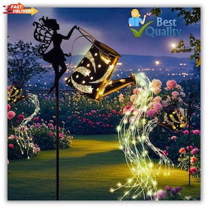 May include: Decorative solar-powered garden lights featuring a fairy silhouette and watering can design. The watering cans have star cutouts and emit a warm glow, with strings of lights cascading down. The scene is set in a garden with pink flowers and a night sky.