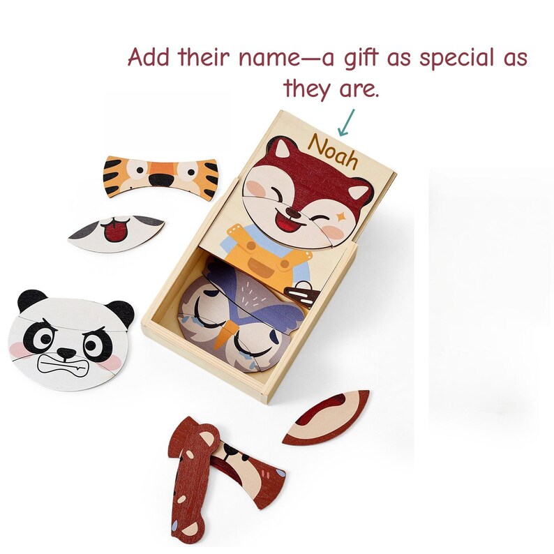 K&ouml;nnte beinhalten: Holzpuzzle-Set mit Tiergesichtern, darunter ein Panda, ein Tiger und ein Fuchs. Die Puzzleteile befinden sich in einer Holzkiste mit dem Namen "Noah" auf dem Deckel. Der Text "Add their name&mdash;a gift as special as they are" ist ebenfalls sichtbar.