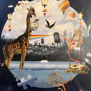 May include: A surreal art print featuring a giraffe carrying a fishbowl, a flamingo, and a hot air balloon. The image includes a rainbow, a cityscape, and the text "HANDMADE CITIES" at the top. The color palette includes blues, browns, and oranges.