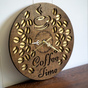 May include: A brown wooden clock with a coffee cup and coffee beans design. The clock face has gold hands and the words "Coffee Time" are written below the clock face.