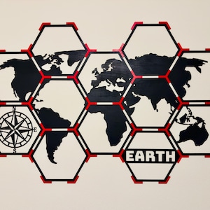 May include: A black and white world map in a honeycomb design with red accents. A compass rose is on the left, and the word "EARTH" is displayed at the bottom. The map is a decorative wall hanging.