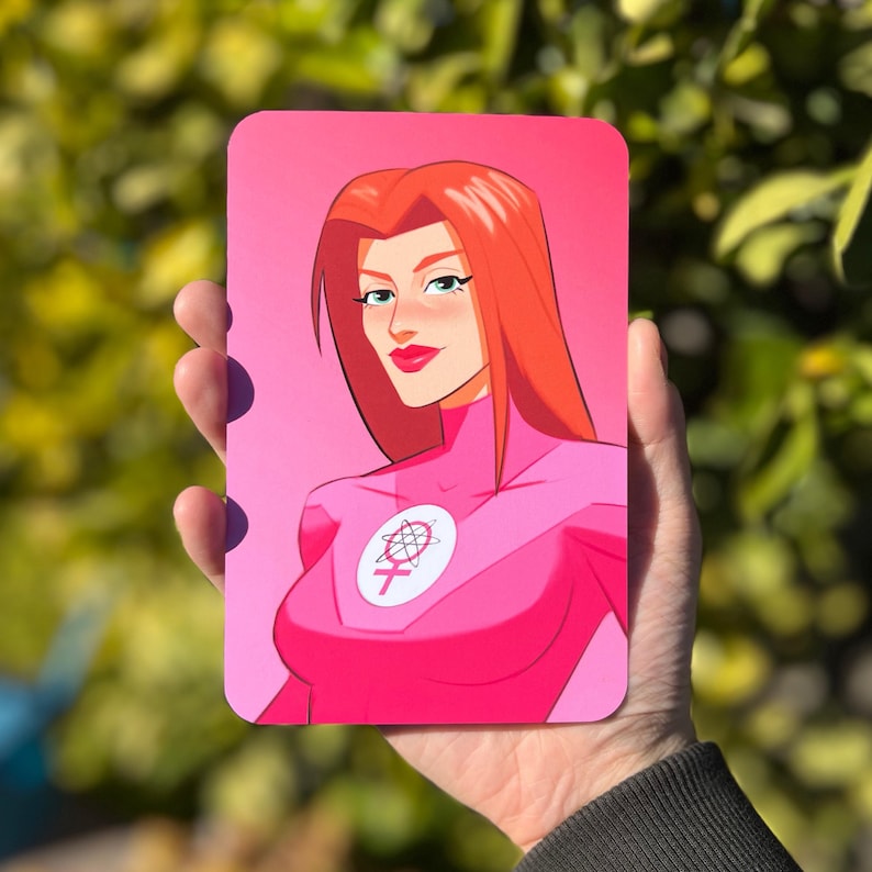 May include: A pink and white illustration of a woman with red hair wearing a pink suit with a symbol of a circle with a female symbol inside. The background is pink.